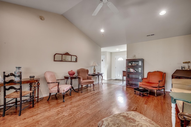 living area with visible vents, baseboards, lofted ceiling, light wood-style flooring, and ceiling fan