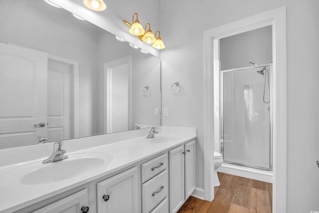 full bath featuring toilet, a stall shower, and a sink