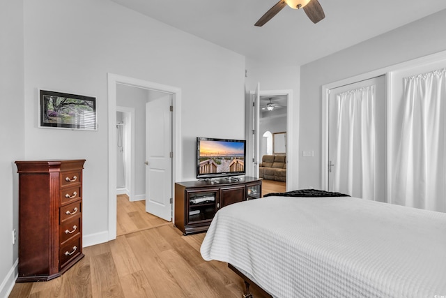 bedroom featuring baseboards, light wood-style floors, and a ceiling fan