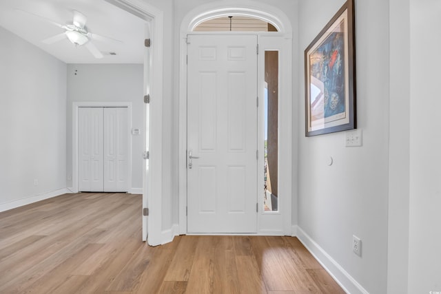 entryway with baseboards, light wood-type flooring, and ceiling fan