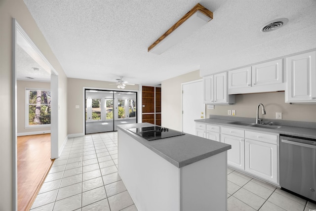 kitchen with black electric cooktop, a sink, visible vents, white cabinets, and stainless steel dishwasher