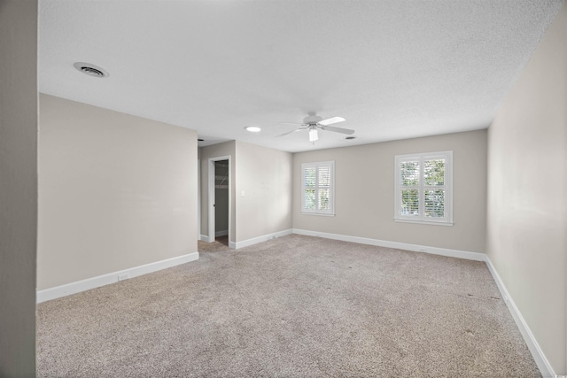 unfurnished room featuring a ceiling fan, light carpet, a textured ceiling, and baseboards