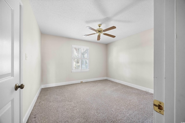 carpeted spare room featuring ceiling fan, baseboards, and a textured ceiling