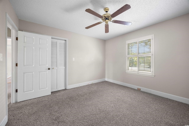 unfurnished bedroom featuring a textured ceiling, carpet, and baseboards