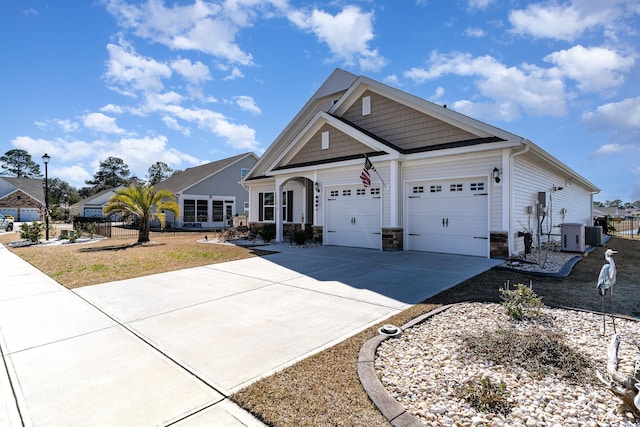 craftsman-style house featuring a garage, driveway, fence, and central air condition unit