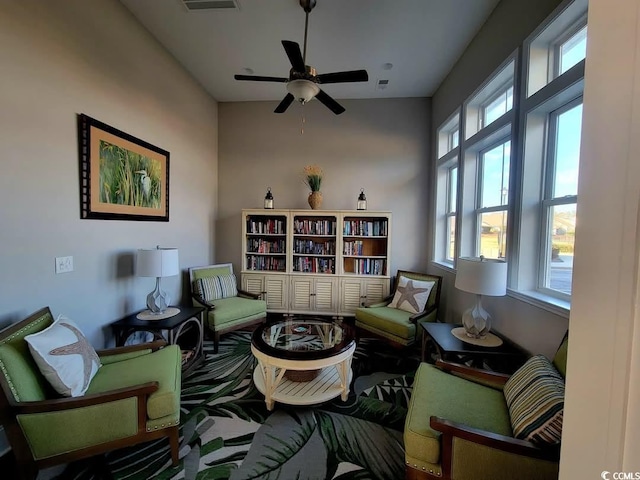 living area featuring ceiling fan and visible vents