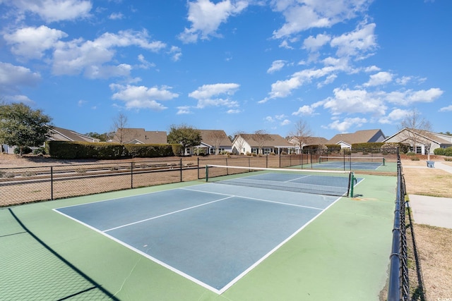 view of sport court featuring fence and a residential view