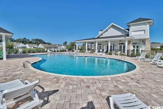 community pool featuring a patio area and fence