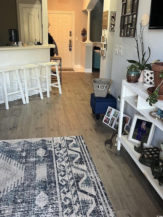 interior space featuring decorative columns and wood finished floors