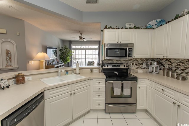 kitchen featuring stainless steel appliances, a sink, light countertops, and decorative backsplash