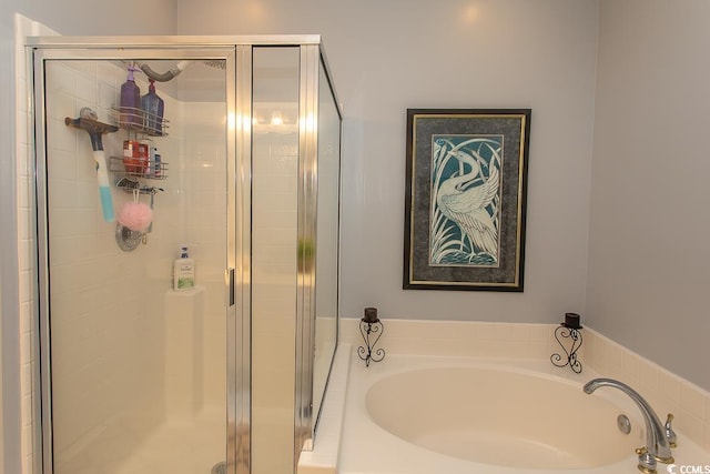 bathroom featuring a stall shower and a bath