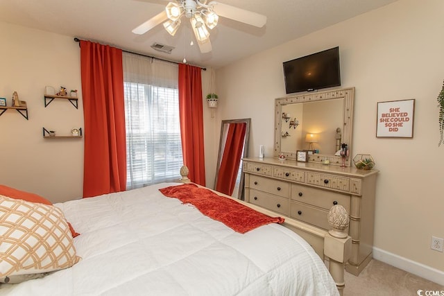 carpeted bedroom featuring ceiling fan, visible vents, and baseboards