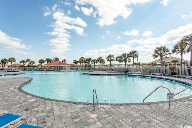 community pool featuring fence and a patio