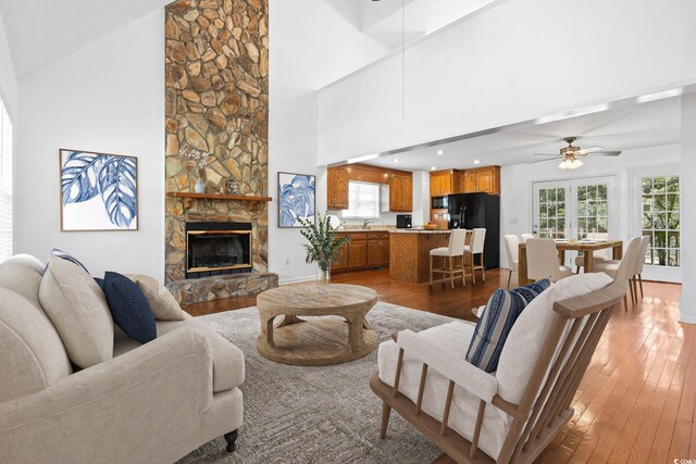 3615 Sunfish St, Murrells Inlet, SC 29576 - living room with a stone fireplace, a healthy amount of sunlight, high vaulted ceiling, and wood-type flooring