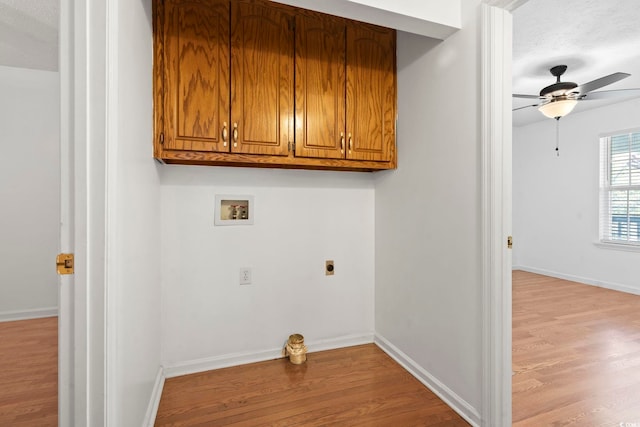 laundry room featuring light wood finished floors, cabinet space, baseboards, hookup for a washing machine, and hookup for an electric dryer