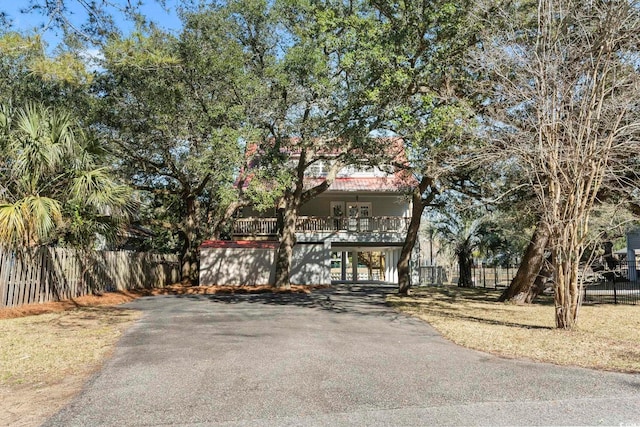 view of front of home featuring stairs, driveway, a porch, and fence