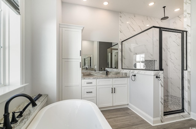 bathroom with vanity, a marble finish shower, and wood finished floors