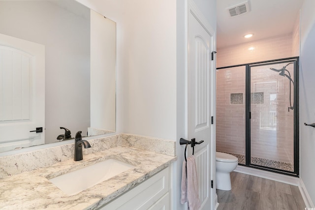 full bathroom featuring visible vents, toilet, a stall shower, vanity, and wood finished floors