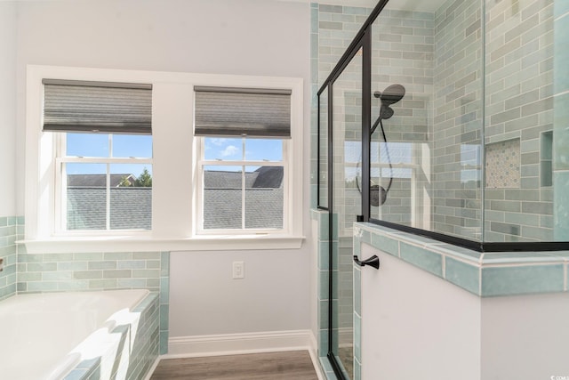 bathroom featuring a stall shower, plenty of natural light, baseboards, and wood finished floors