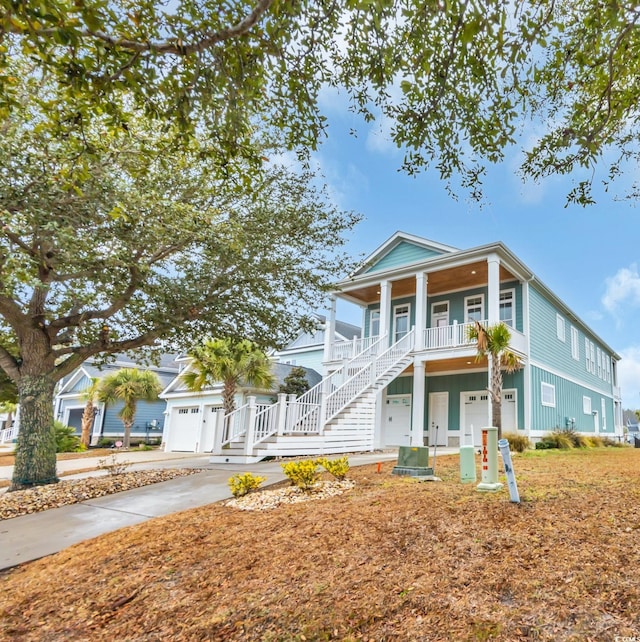 view of front facade with covered porch, stairs, and concrete driveway