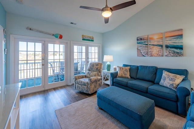 living area with visible vents, lofted ceiling, ceiling fan, wood finished floors, and french doors