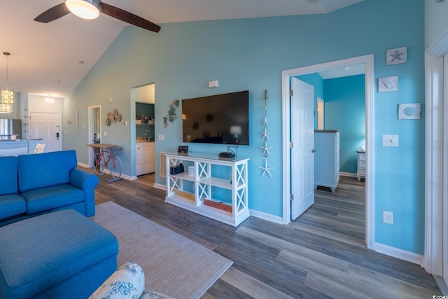 living room featuring washer / dryer, baseboards, ceiling fan, wood finished floors, and beam ceiling