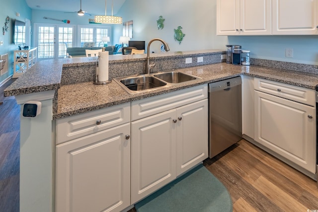 kitchen featuring a peninsula, a sink, white cabinets, stainless steel dishwasher, and pendant lighting