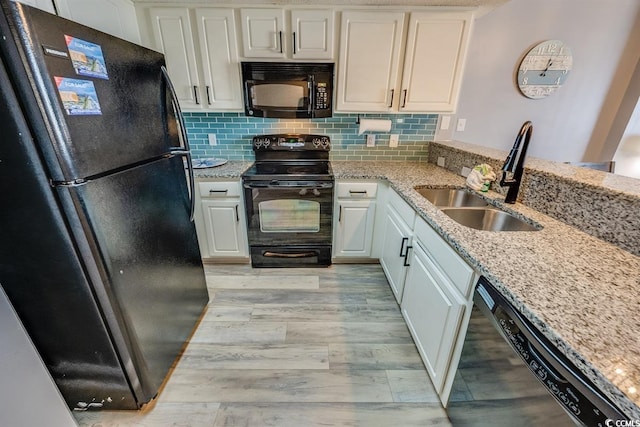 kitchen with decorative backsplash, white cabinets, a sink, and black appliances