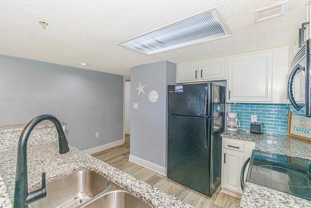 205 74th Ave N Unit 702, Myrtle Beach, SC 29572 - kitchen with freestanding refrigerator, a textured ceiling, light wood finished floors, electric stove, and backsplash