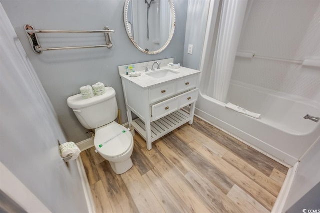 bathroom with toilet, shower / bath combo, vanity, wood finished floors, and baseboards