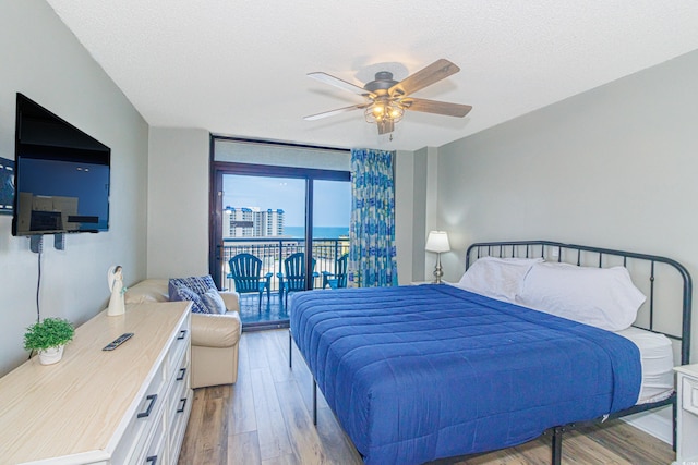 205 74th Ave N Unit 702, Myrtle Beach, SC 29572 - bedroom with access to exterior, wood finished floors, ceiling fan, and a textured ceiling