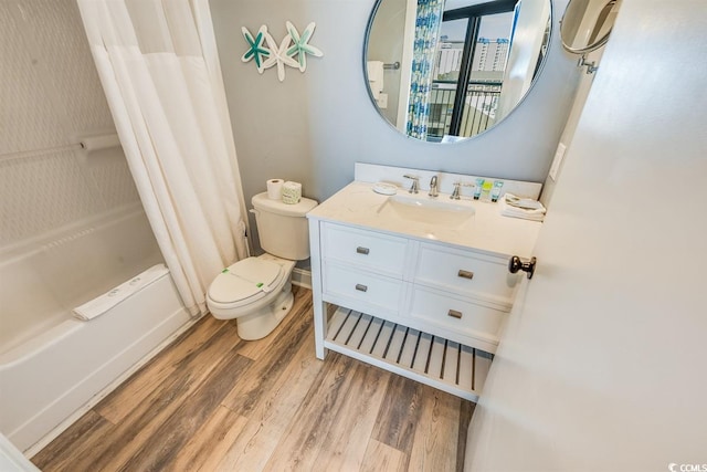 full bath with toilet, shower / bath combo, wood finished floors, and vanity