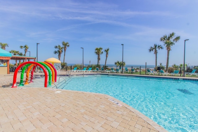 view of swimming pool featuring fence