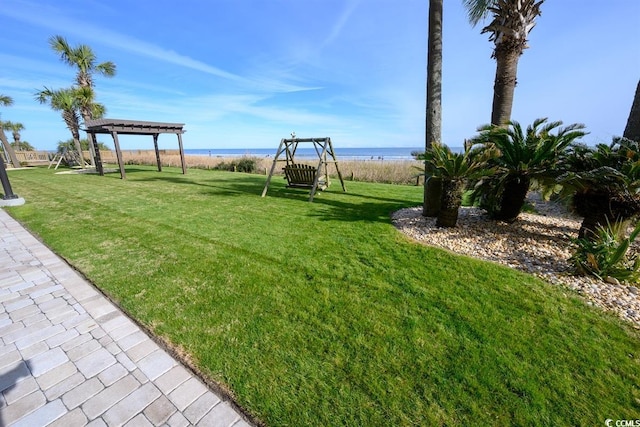 view of yard with playground community, a water view, and a pergola