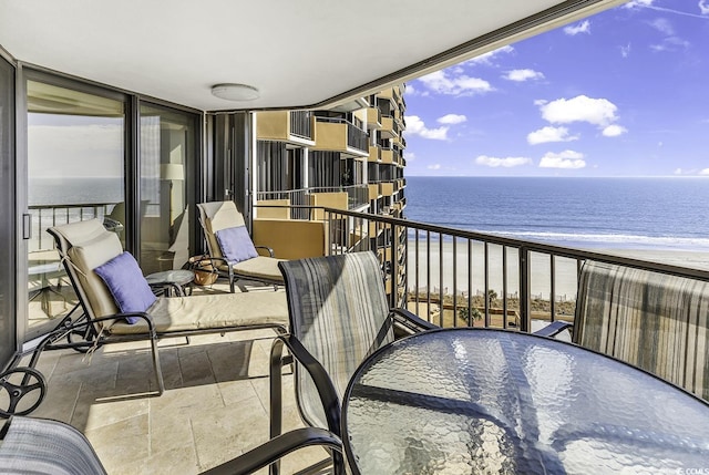 balcony featuring a beach view and a water view