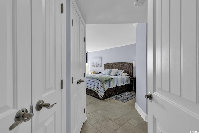 bedroom with baseboards and stone tile flooring