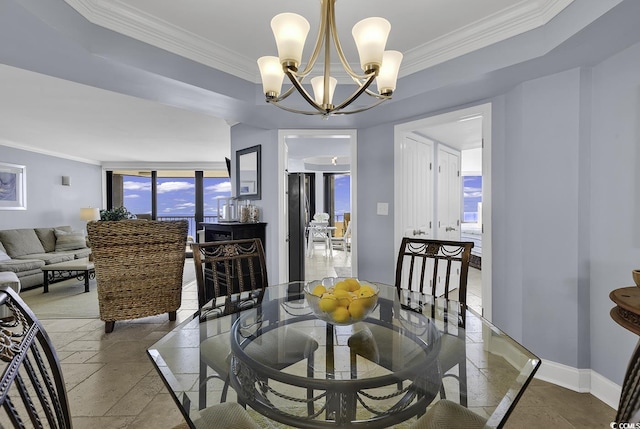 dining area featuring baseboards, crown molding, a notable chandelier, and stone tile floors