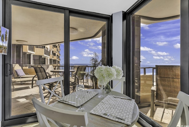 sunroom featuring a water view and a wealth of natural light