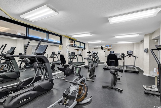 workout area with baseboards and a textured ceiling