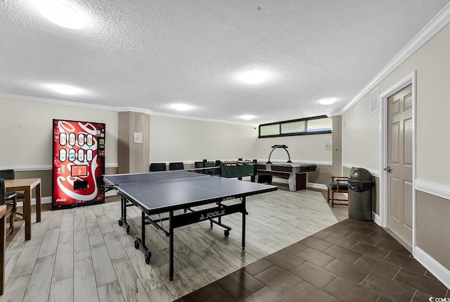 rec room featuring a textured ceiling, wood tiled floor, visible vents, and crown molding