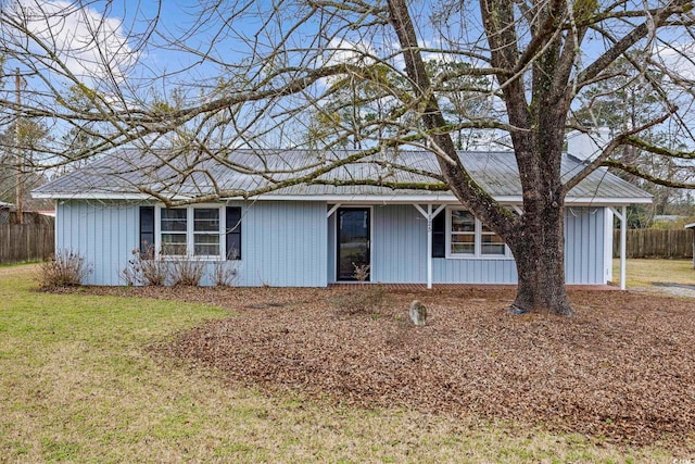 view of front of home featuring fence and a front lawn