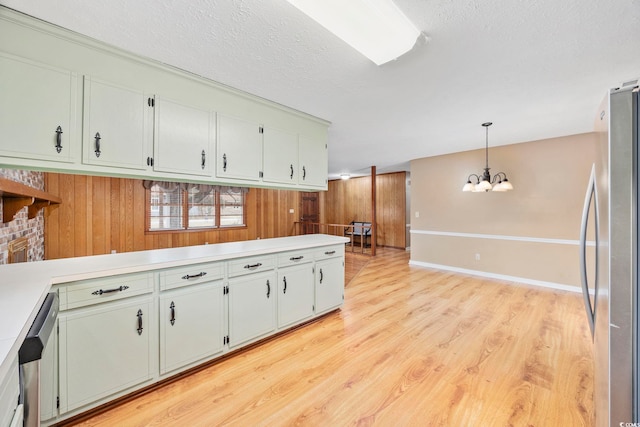 kitchen featuring decorative light fixtures, a notable chandelier, light wood finished floors, stainless steel appliances, and light countertops