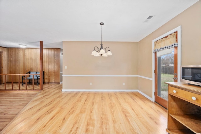 dining area with light wood finished floors, baseboards, visible vents, and a notable chandelier