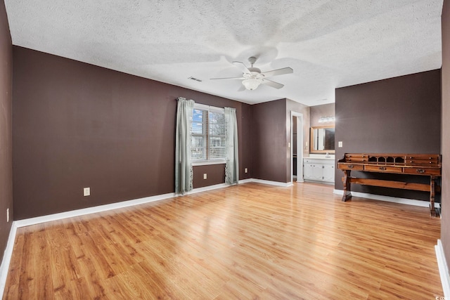 unfurnished living room featuring light wood finished floors, visible vents, baseboards, a ceiling fan, and a textured ceiling