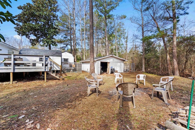 view of yard with an outdoor fire pit, a deck, and an outbuilding