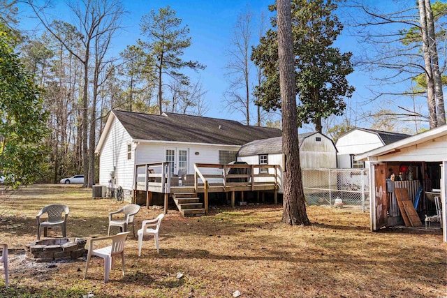 back of house with an outdoor fire pit, cooling unit, fence, and a wooden deck