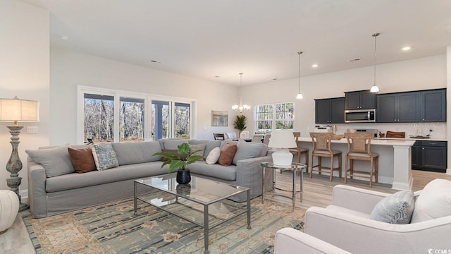 living area featuring recessed lighting, a notable chandelier, light wood finished floors, and visible vents