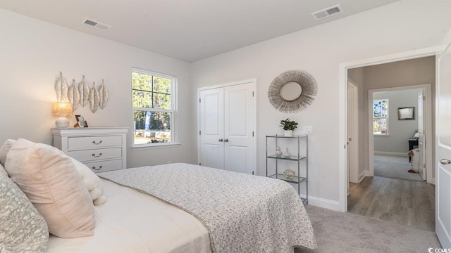 bedroom featuring baseboards, visible vents, a closet, and carpet