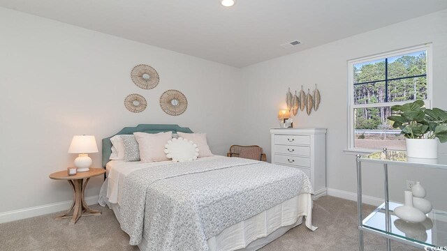carpeted bedroom featuring baseboards and visible vents
