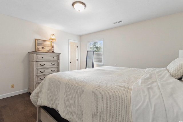 bedroom with dark wood-style flooring, visible vents, and baseboards